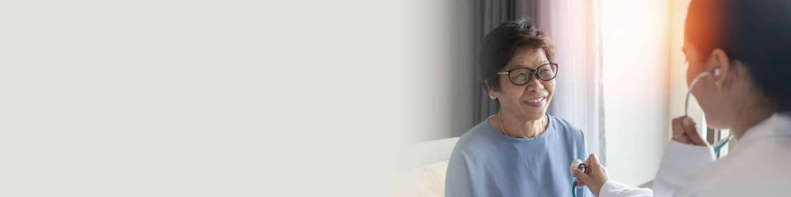 A nurse helping an elderly woman