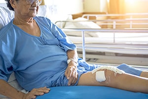 woman in a nursing home bed needing wound care on her leg