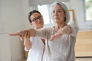 elderly woman with rehab therapist helping with vertigo and balance treatment