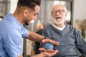 elderly man with rehab therapist helping with grip and balance treatment